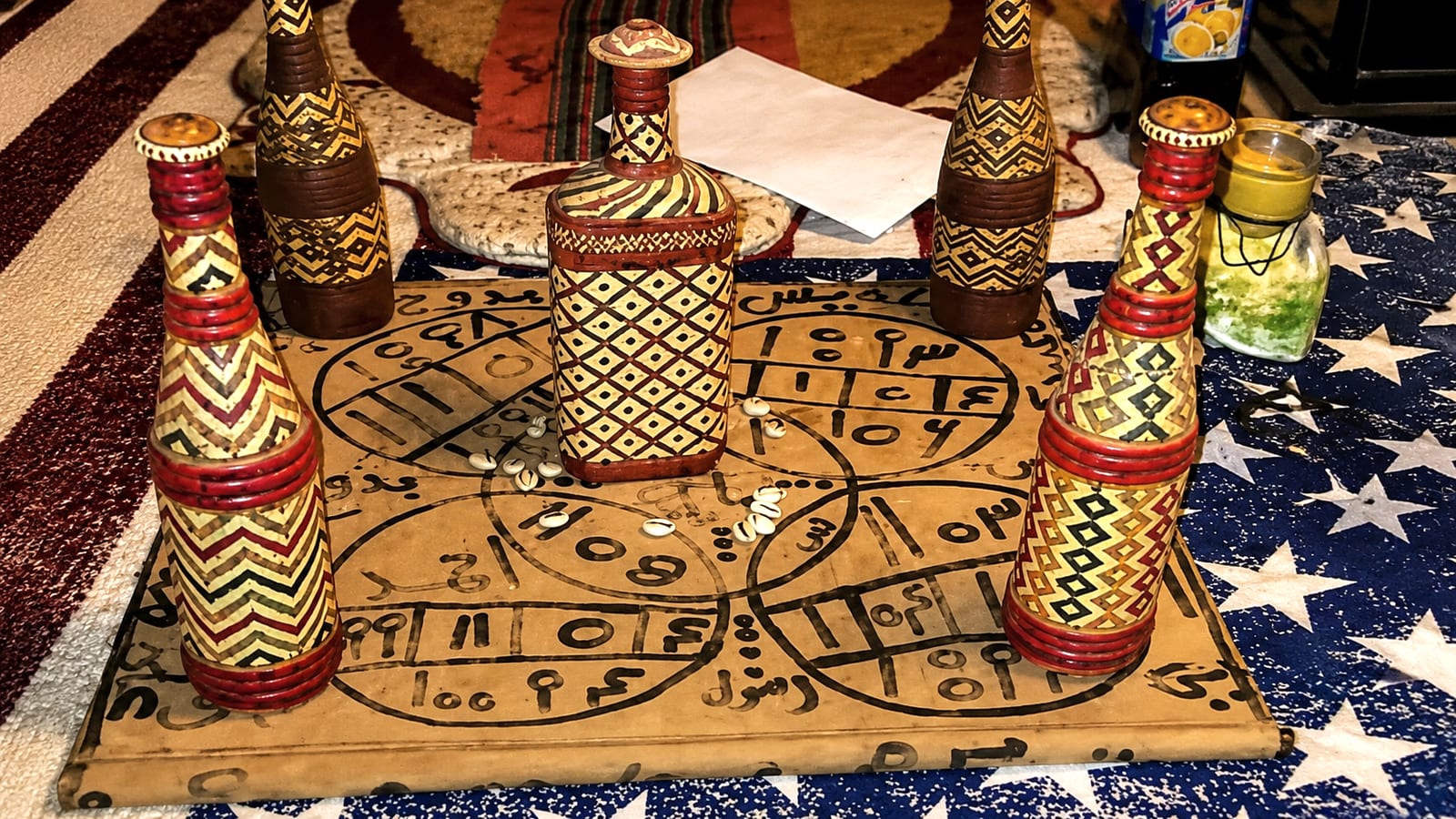 Planche géomantique gravée entourée de flacons décorés