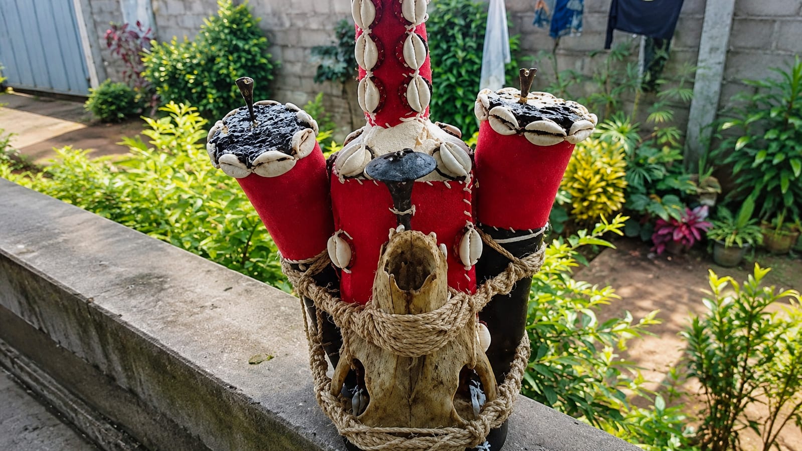 Talismans traditionnels en tissu rouge ornés de cauris